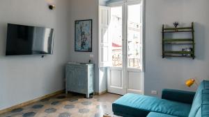 a living room with a blue couch and a television at Casa Sinatra by Rentbeat in Taranto