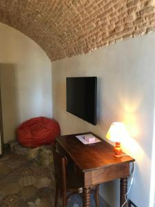 una stanza con un tavolo e una TV su una parete di Camera Matilde a Cervo