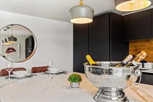 a kitchen with a table with a bowl of wine bottles at River cabin & Mills Cottage in Henley on Thames +67 photos