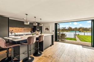 an open kitchen with a large sliding glass door to a patio at River cabin & Mills Cottage in Henley on Thames