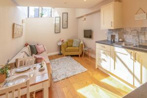 a kitchen with a sink and a living room at Belle-Suite - Charming Cotswolds Historic Apartment in Stow-on-the-Wold in Stow on the Wold