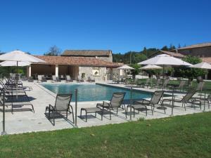a group of chairs and umbrellas next to a pool at Les Ecuries du Chille in Jaujac