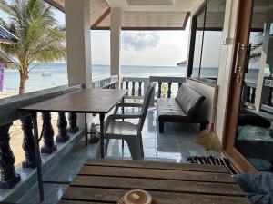 a table and chairs on a balcony with the beach at Euphoria Bungalow in Haad Yao