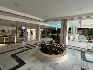 a lobby with a planter in the middle of a building at Panoramic Views Cozy Apt Benalmádena Center in Benalmádena +22 photos