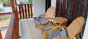 a porch with two wicker chairs and a table at Sigiri Inn in Kibissa