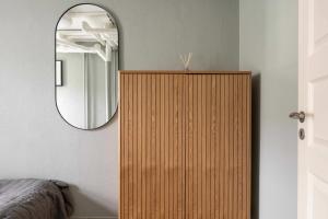 - une armoire en bois dans une chambre avec un miroir dans l'établissement 2 BR Apartment in Heart of Vesterbro, à Copenhague 30 autres photos