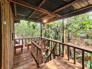 a wooden porch of a house with a view of the forest at Ratanakiri Homestay & Jungle Trek in Banlung
