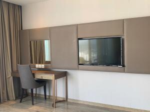 Una habitación de hotel con un escritorio y un televisor. en Panorama Nha Trang Sapphire, en Nha Trang 2 fotos más