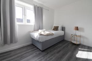 una camera da letto bianca con un letto e una finestra di Renfrew House a Renfrew