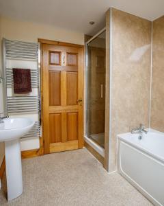 a bathroom with a tub and a sink and a shower at Courtyard Cottage in Tomich +14 photos