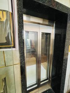 a reflection of a glass elevator in a mirror at Hotel Supreme Stay in Jodhpur