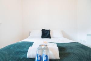 two bottles of water sitting on top of a bed at Argyle Place in Glasgow