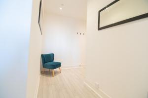 a blue chair in a white room with a mirror at Argyle Place in Glasgow