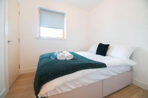 a bedroom with a bed with white sheets and a window at Argyle Place in Glasgow