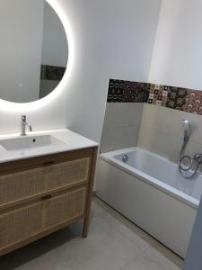 HeudicourtにあるMaison Origines pour 2 personnesの洗面台、浴槽、鏡のあるバスルーム