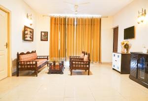 LāndrānRefined 3BR Independent Apt in Tricity Mohali的带椅子、沙发和桌子的客厅