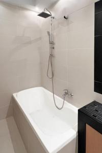 a bathroom with a bath tub with a shower at Rona Vista Suites Sea view modern living in Polykhrono