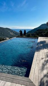 a swimming pool with a wooden deck and water at Villa Porra 100m2, pleine nature, piscine, vue mer in Porto-Vecchio