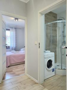 a bathroom with a washing machine and a bedroom at Lucky-Time pl - 2 pokoje - Ostrów Tumski in Wrocław