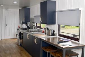 eine Küche mit blauen Schränken und einer Arbeitsplatte aus Holz in der Unterkunft Lagavulin 3 in Portpatrick