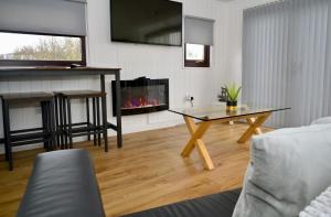 ein Wohnzimmer mit einem Tisch und einem Kamin in der Unterkunft Lagavulin 3 in Portpatrick
