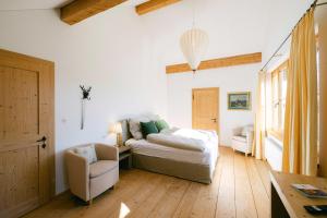 una camera da letto con un letto e una sedia di Forthuber Landhaus - Self Check-in möglich a Feldkirchen bei Mattighofen