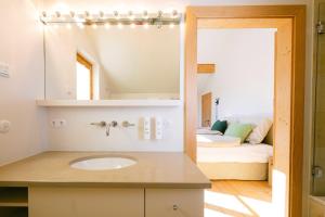 un bagno con lavandino, specchio e letto di Forthuber Landhaus - Self Check-in möglich a Feldkirchen bei Mattighofen