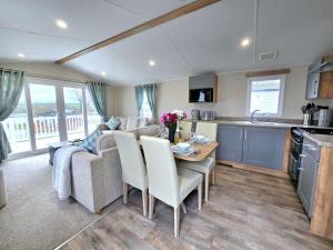 a kitchen and living room with a table and a couch at Cornwall Caravan Retreat 3 Crantock in Crantock