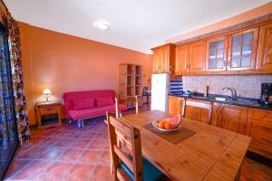 a kitchen with a wooden table and a red couch at Große Dachwohnung mit Blick auf das Meer in Valle Gran Rey