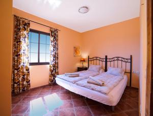 a bedroom with a bed and a large window at Große Dachwohnung mit Blick auf das Meer in Valle Gran Rey