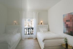 戈尔德格Seehof Goldegg的一间有两张床和一扇窗户的白色房间 更多37张照片