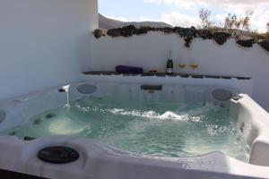 a jacuzzi tub with water in it at Daidas Beach House - with hot whirlpool in Famara in Famara +25 photos