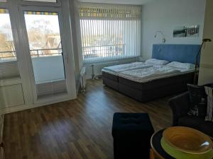 a bedroom with a bed and a couch and windows at Strandhotel 27 in Dahme