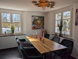 a dining room with a wooden table and chairs at Hotel Nüller Hof in Wuppertal