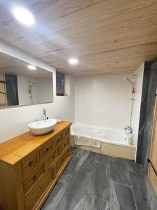 a bathroom with a sink and a bath tub at Mas Du tel, moment nature in Sumène