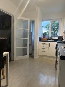 a kitchen with white cabinets and a large window at Blackley Rustic Gem A Manchester Suburb Hideaway in Manchester