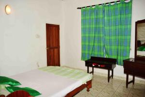 a bedroom with a bed and a dresser and a mirror at Sampathaa Residence in Negombo
