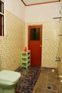 a bathroom with a toilet and a red door at Sampathaa Residence in Negombo +52 photos