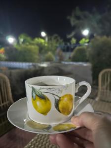 a person holding a coffee cup with lemons on it at Covenant Farmhouse in Evangelista