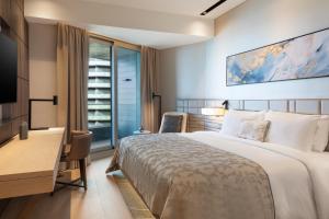 a bedroom with a bed and a desk and a television at JW Marriott Hotel Istanbul Marmara Sea in Istanbul