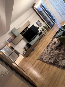 un soggiorno con TV e pavimento in legno di Uno Retreat Residence a Braşov Altre 17 foto