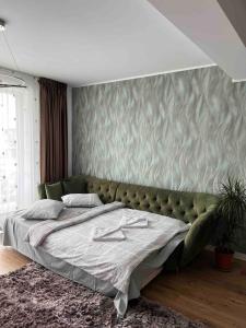 una camera con un letto verde e una parete di Uno Retreat Residence a Braşov