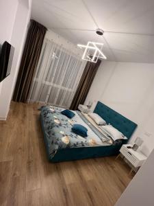una camera da letto con un letto con un piumone blu di Uno Retreat Residence a Braşov