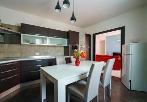 cocina con mesa blanca, sillas y nevera en Guest Friends, en Trapani