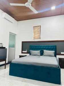 a blue bed in a white room with a ceiling at Millennium Luxury Apartments in Negombo