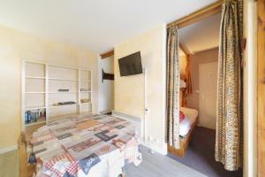 a bedroom with a bed and a tv on a wall at Le Nid de Gourette - Au Pied des Pistes in Eaux-Bonnes +6 photos