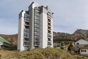 a tall white building on top of a hill at Le Nid de Gourette - Au Pied des Pistes in Eaux-Bonnes