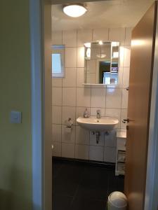 WassenachにあるGemüliche Ferienwohnung Schmandinの洗面台と鏡のあるバスルーム