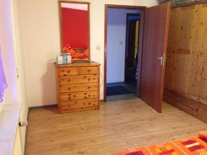 WassenachにあるGemüliche Ferienwohnung Schmandinのベッドルーム(木製ドレッサー、ドア付) +16枚の写真