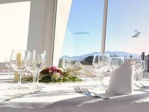 una mesa con copas de vino y un mantel blanco en Pietrabianca Exclusive Resort, en Pomigliano dʼArco